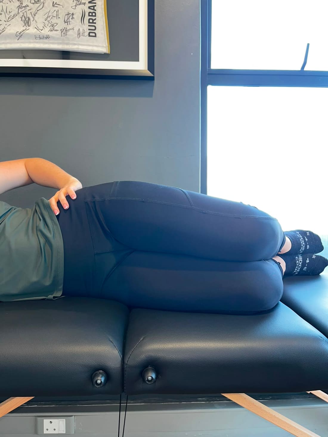 Hannah demonstrating the starting position of a side-lying clamshell