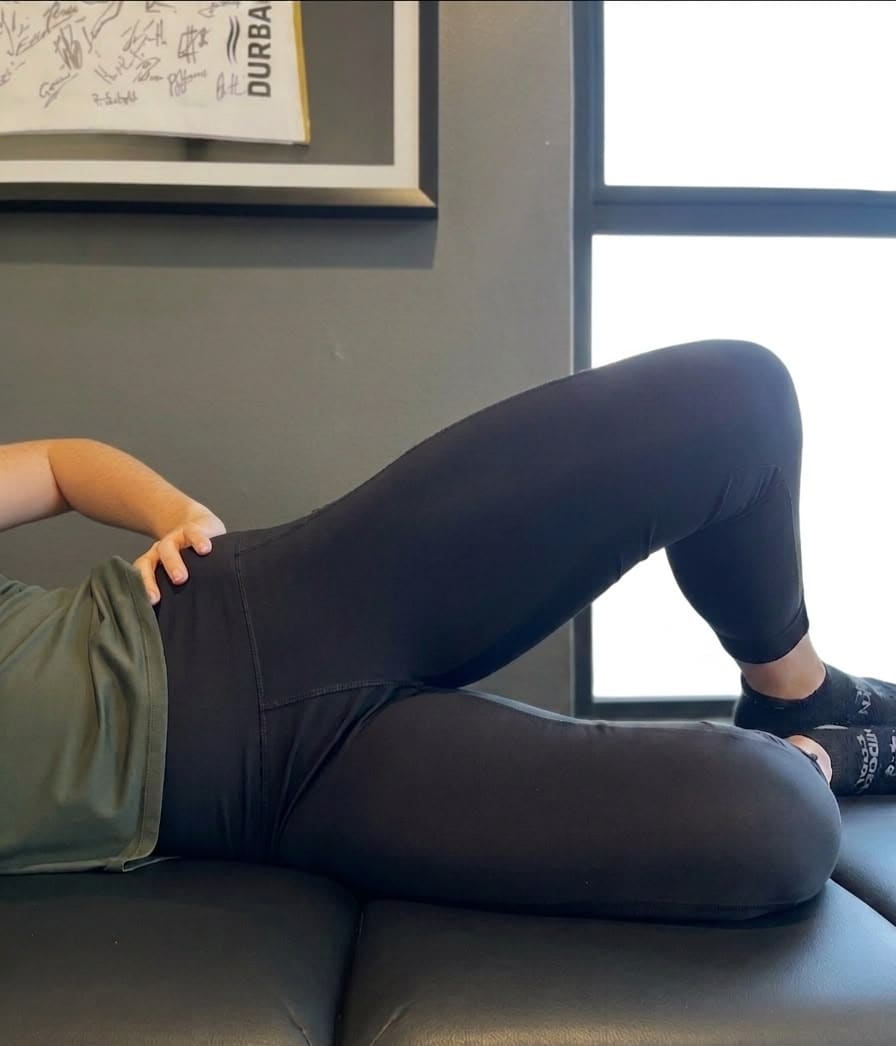 Hannah demonstrating the top position of a side-lying clamshell